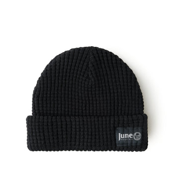 Black knit beanie with a visible brand label on a white background